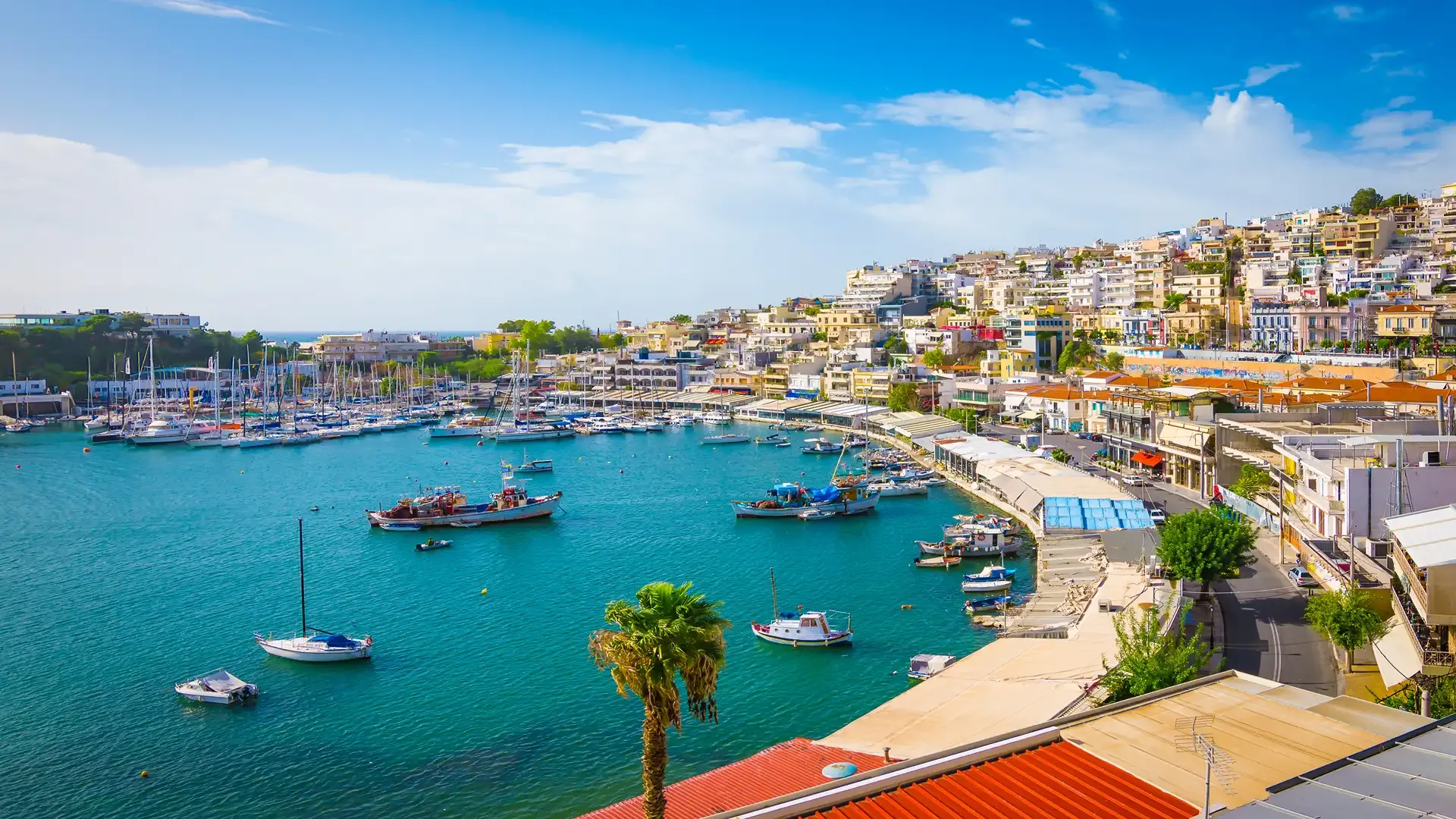 Colorful Hillside Harbor with Moored Boats A vibrant Mediterranean coastal town nestled on a steep hillside overlooking a brilliant turquoise