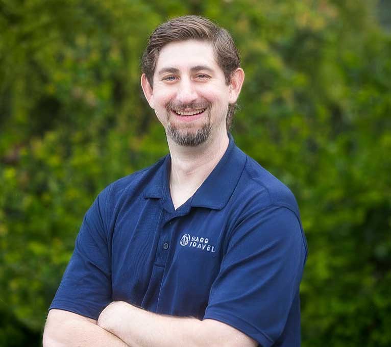 Professional Staff Member Outdoor Portrait A smiling professional staff member wearing a navy blue polo shirt with an embroidered logo
