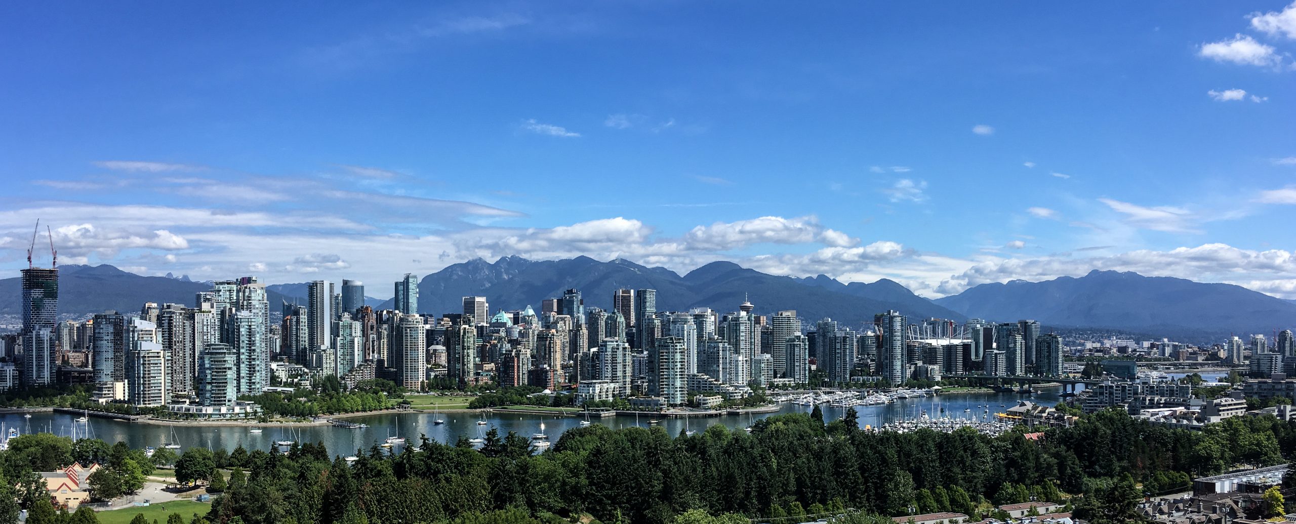 A panoramic view of Vancouver's downtown skyline featuring modern high-rise buildings, the North