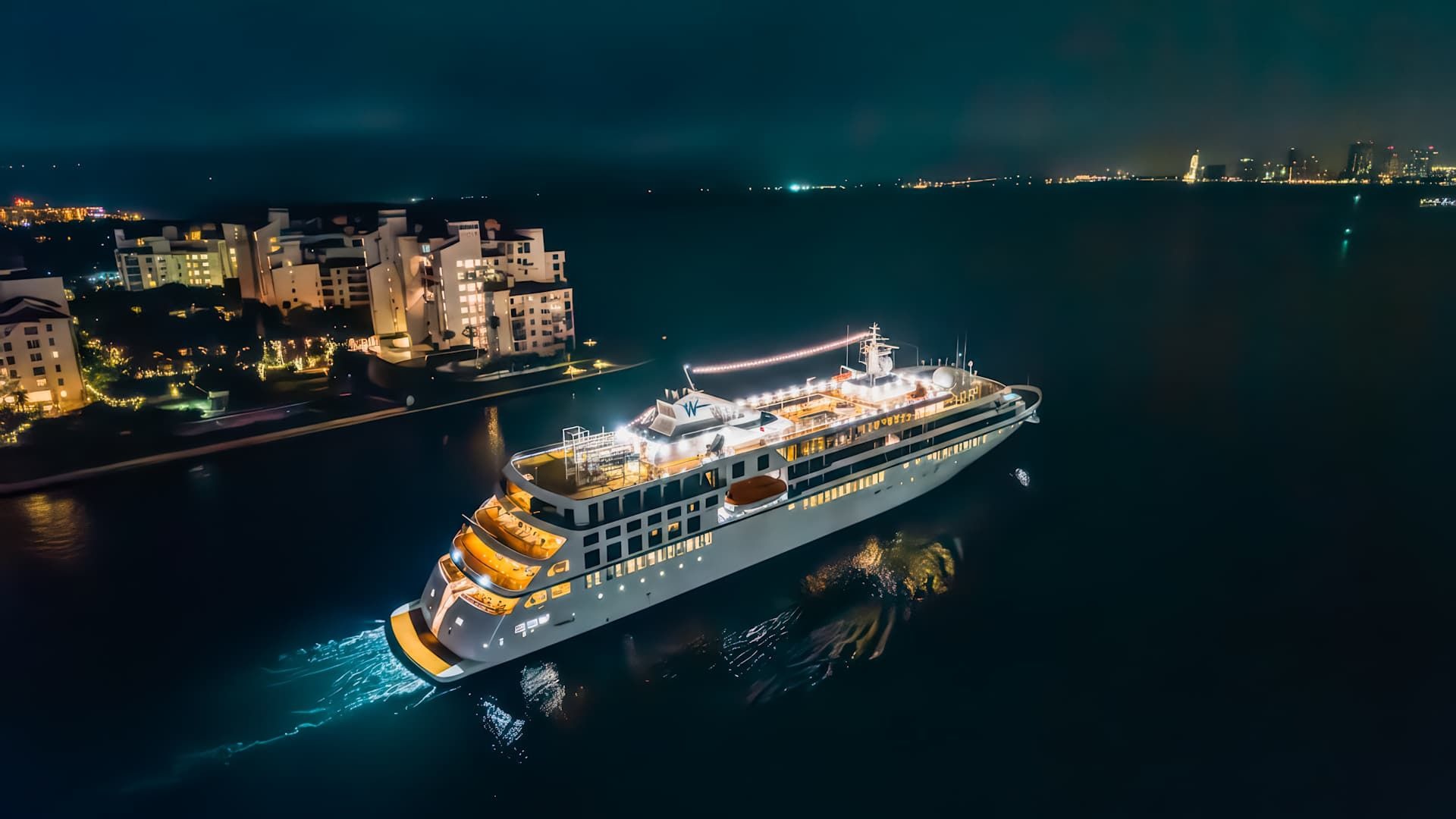Windstar Cruises Ship Anchored Near Miami at Night An illuminated luxury cruise ship from Windstar Cruises is anchored in turquoise waters near Miami