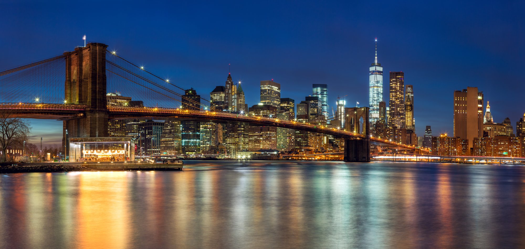 Brooklyn Bridge and Manhattan Skyline at Twilight An iconic nighttime view of the illuminated Brooklyn Bridge spanning the East River with
