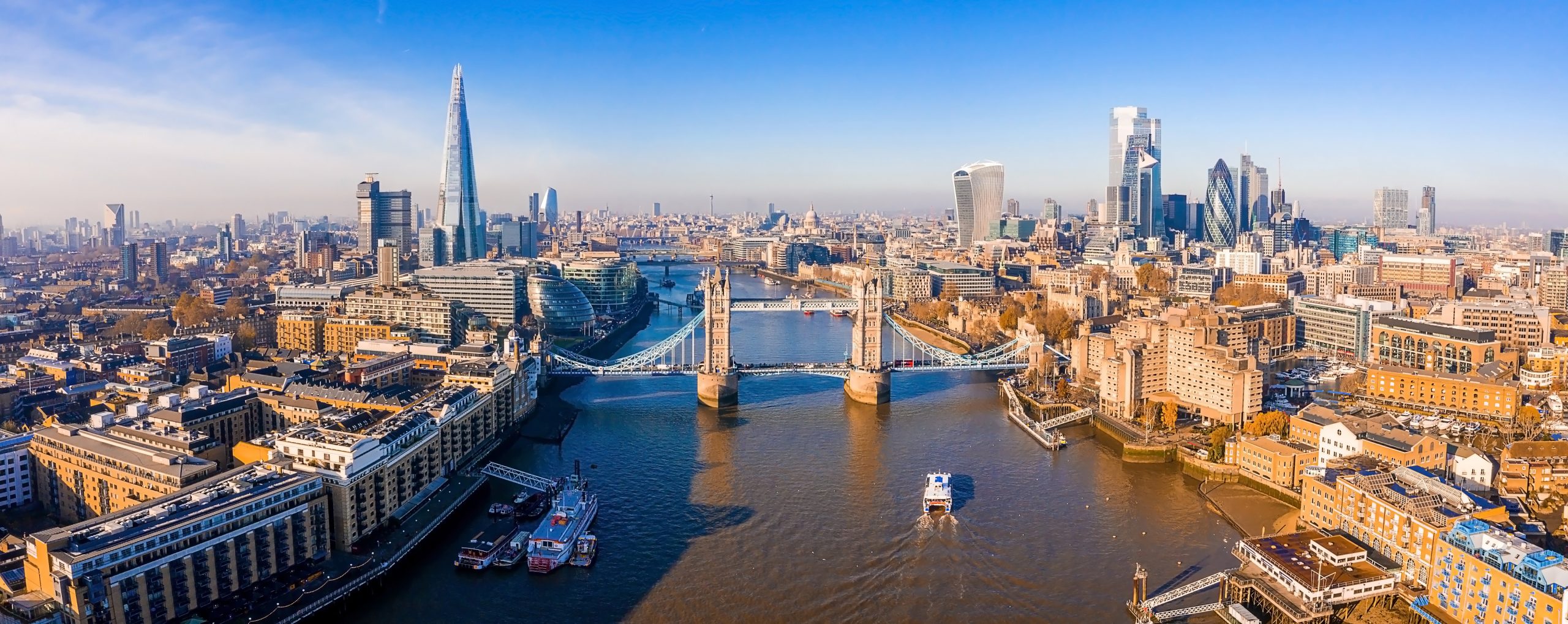 London Skyline with Tower Bridge and Thames River An expansive aerial view of London's iconic skyline featuring Tower Bridge spanning the River